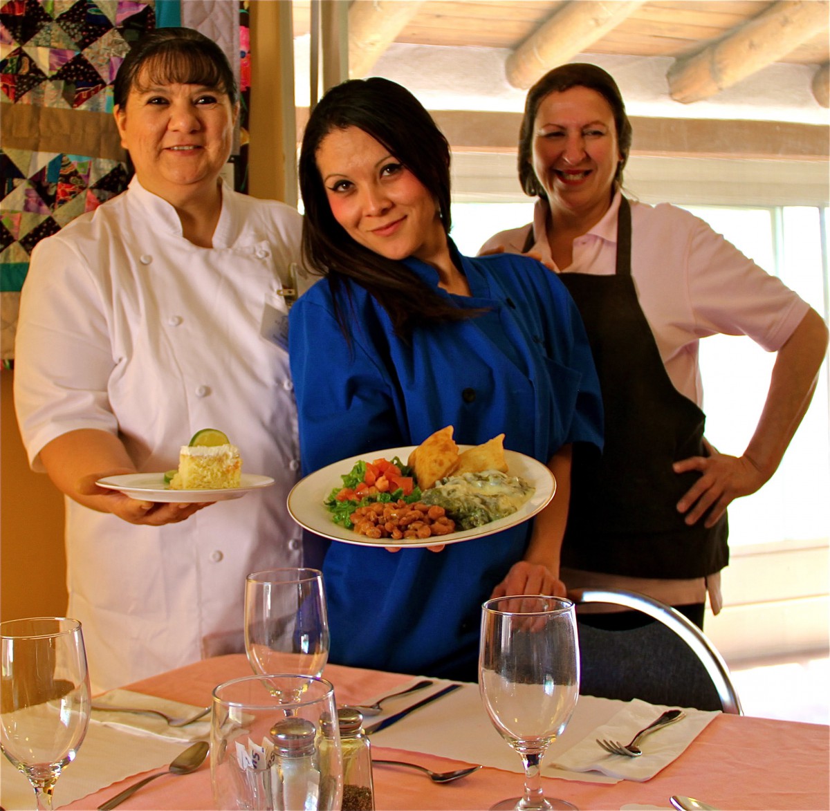Chefs proudly display their culinary creations in a restaurant setting.