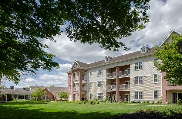 A view of a residential apartment building surrounded by greenery and trees.