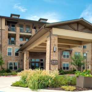 A modern apartment complex with a prominent entrance and well-maintained landscaping.