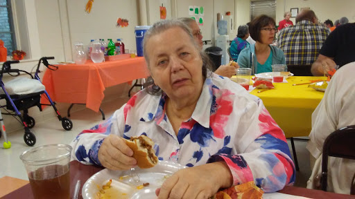 A woman enjoying a meal at a community gathering.