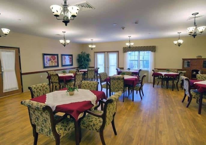A well-furnished dining area with tables and chairs, featuring elegant decor and chandeliers.