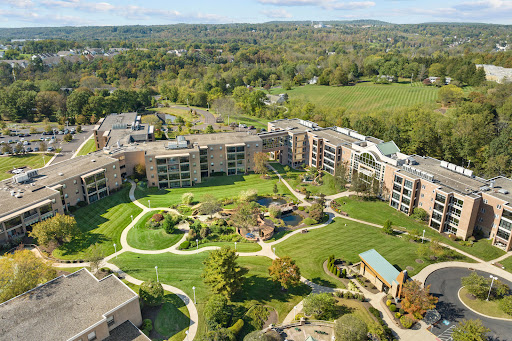 Aerial view of a well-designed residential complex surrounded by lush greenery.