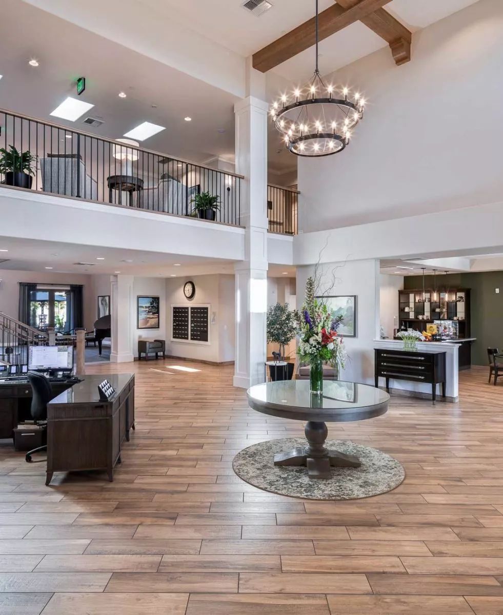 Spacious and elegantly designed lobby with a large chandelier, comfortable seating, and decorative plants.