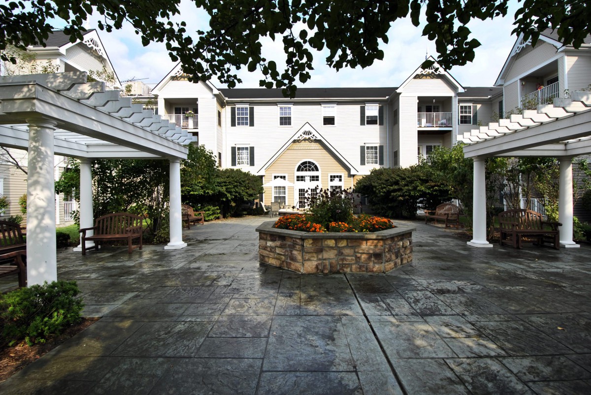 A modern building with a landscaped courtyard and stone pathway.
