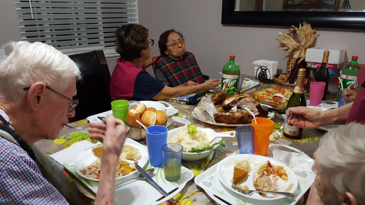 Family gathering around a dinner table with various dishes.