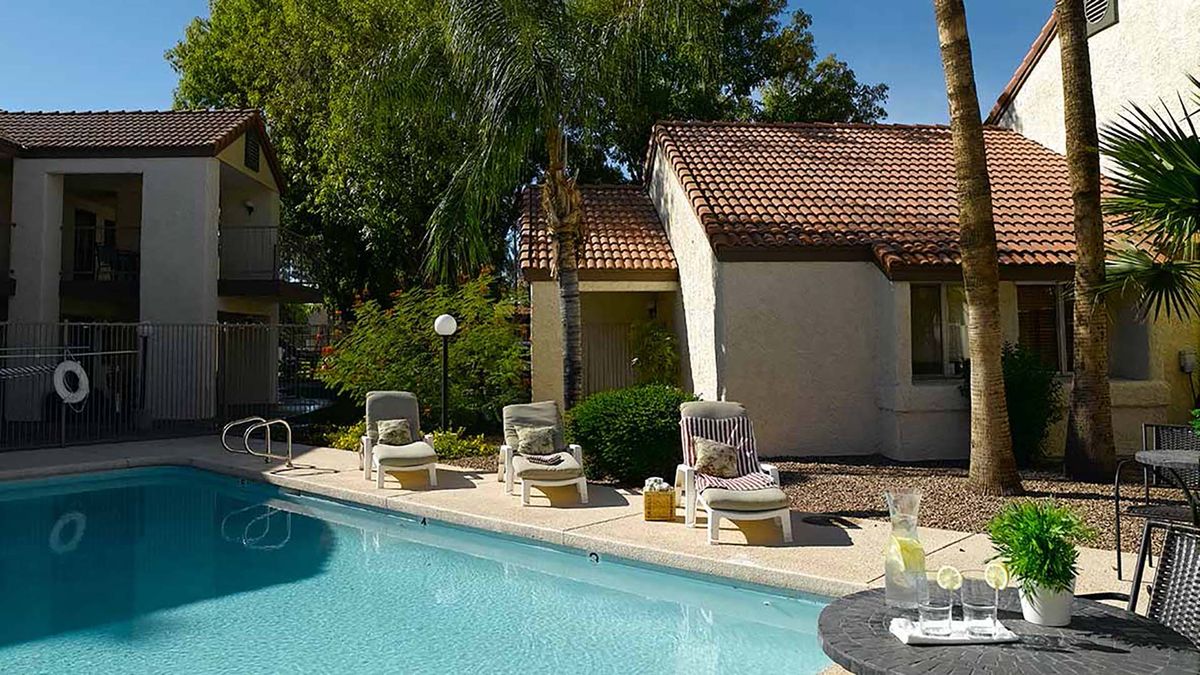 A sunny day at the resort with lounge chairs by the pool.
