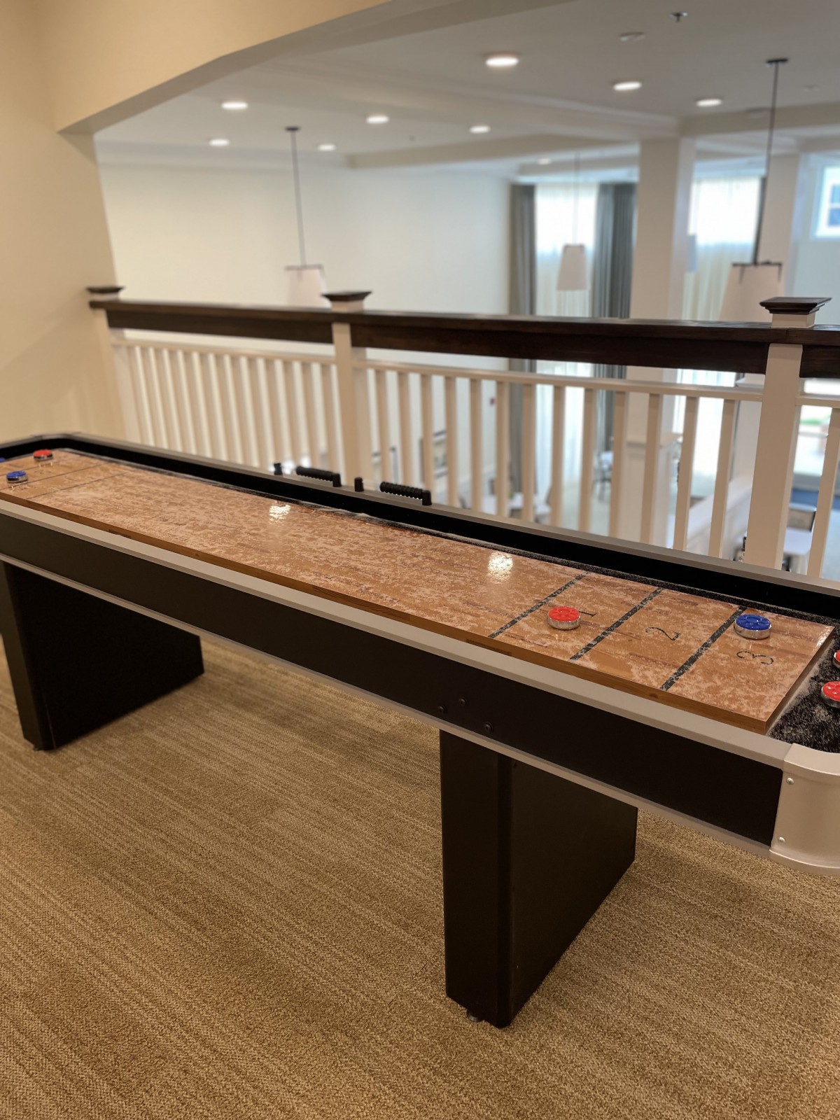 A shuffleboard table set up in a recreational indoor space.