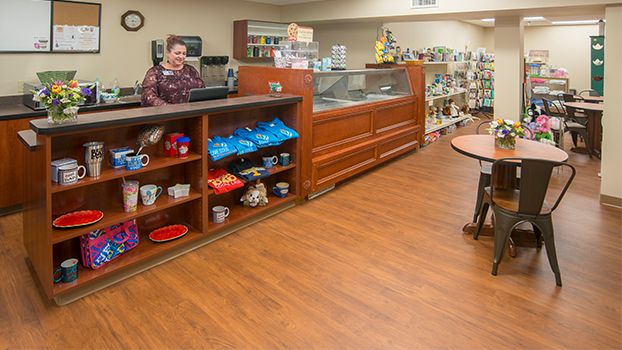 A store interior with a counter and display case, featuring various products on shelves.