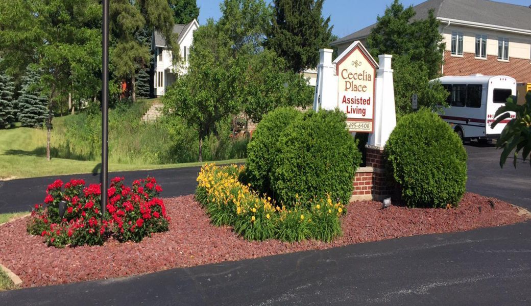 Entrance to an assisted living facility with vibrant flowers and well-maintained landscaping.
