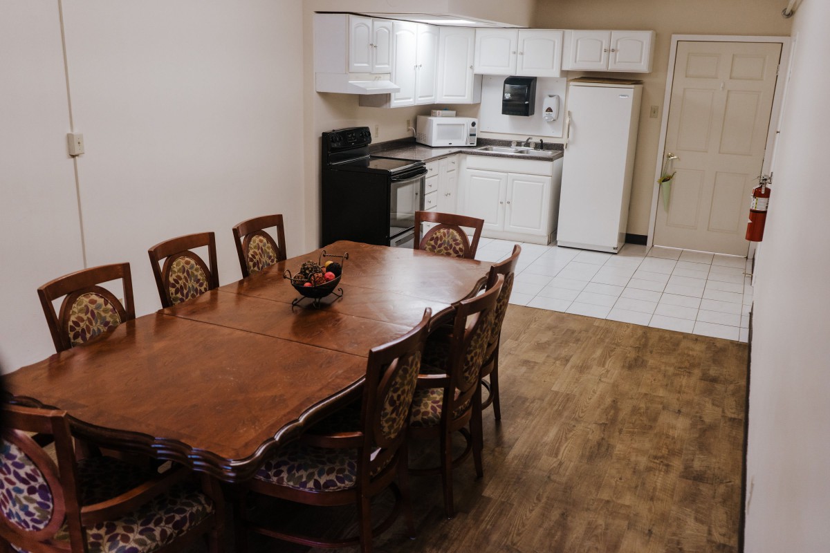 A cozy dining and kitchen area with a wooden table and modern appliances.