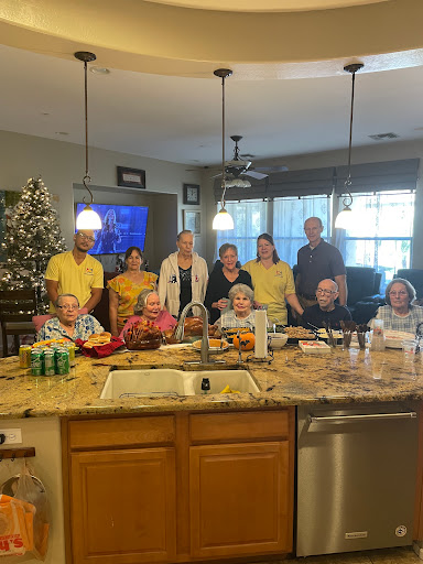 A joyful gathering of family and friends in the kitchen, celebrating together.