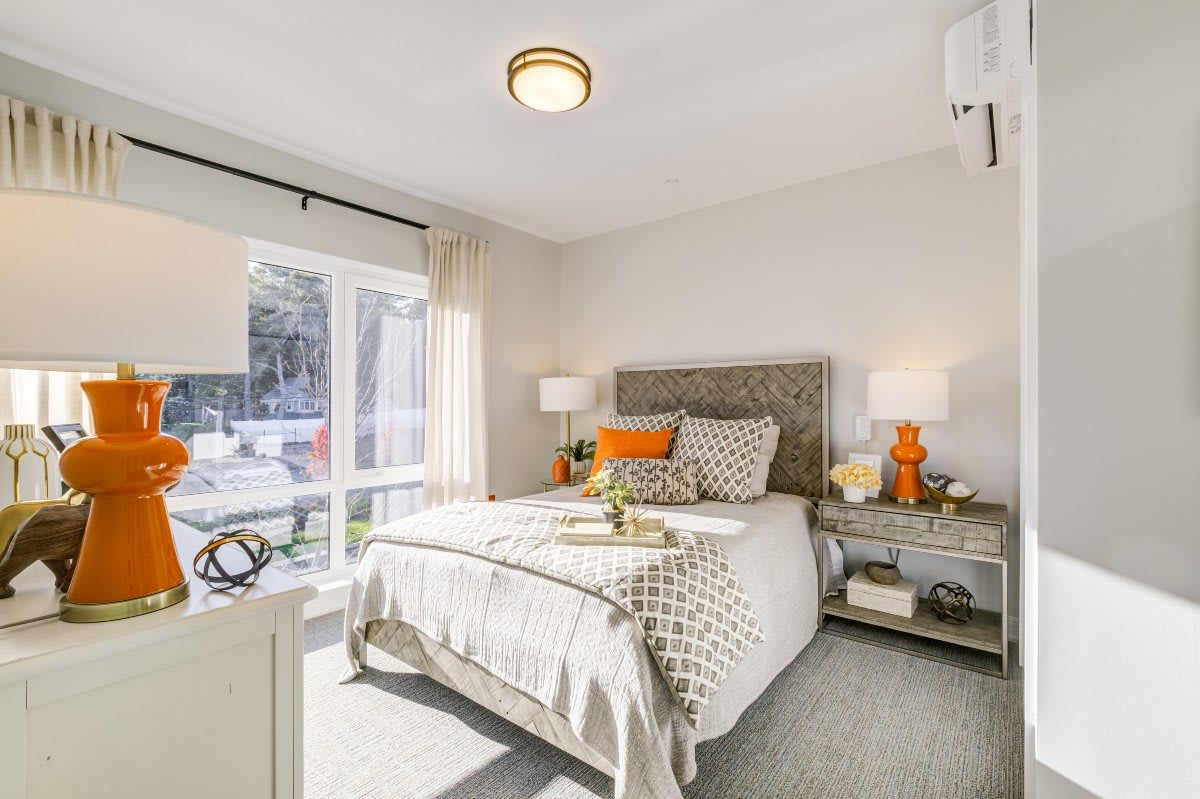 A modern and bright bedroom with stylish decor and a large window.