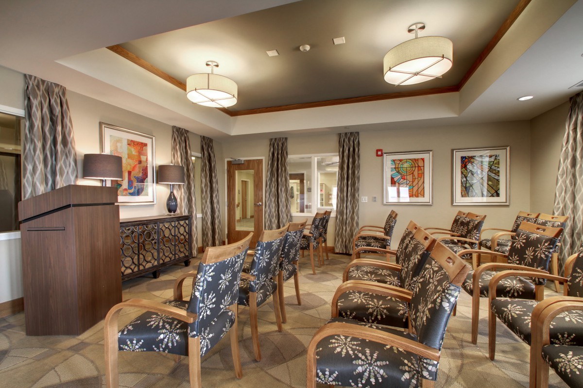 A modern waiting room featuring comfortable seating, decorative lighting, and framed artwork on the walls.