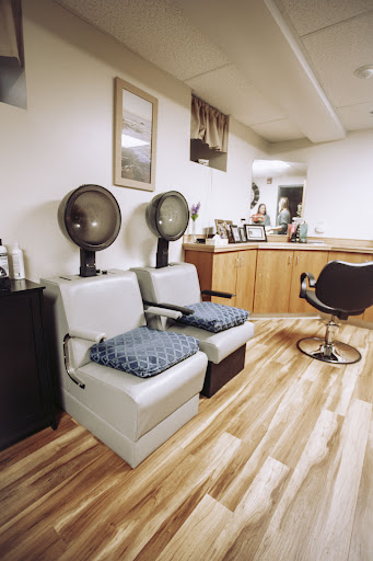 A cozy hair salon setup featuring styling chairs and hair dryers.