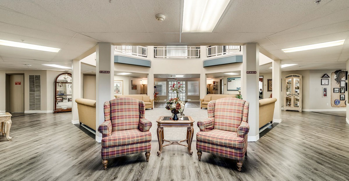 A cozy lobby area featuring two plaid armchairs and a small wooden table.