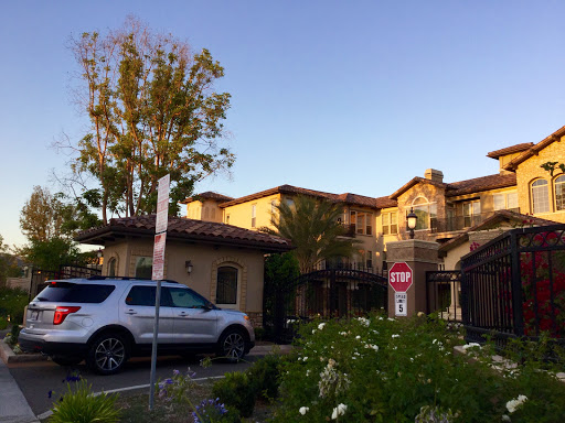 A serene view of a residential building with beautiful landscaping at sunset.