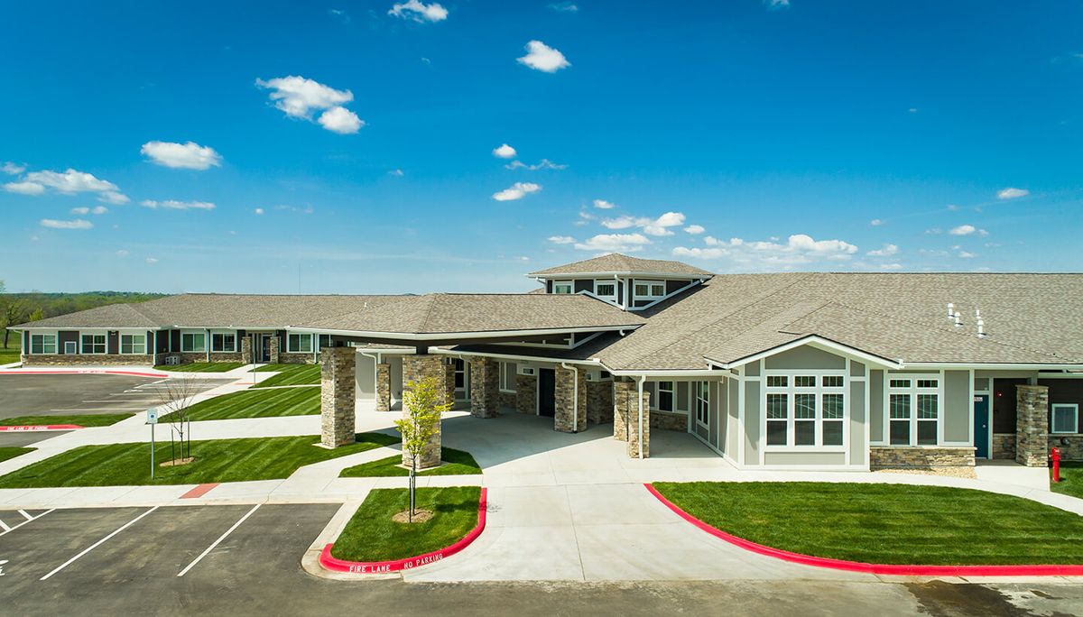 Modern building with a paved driveway and clear skies.