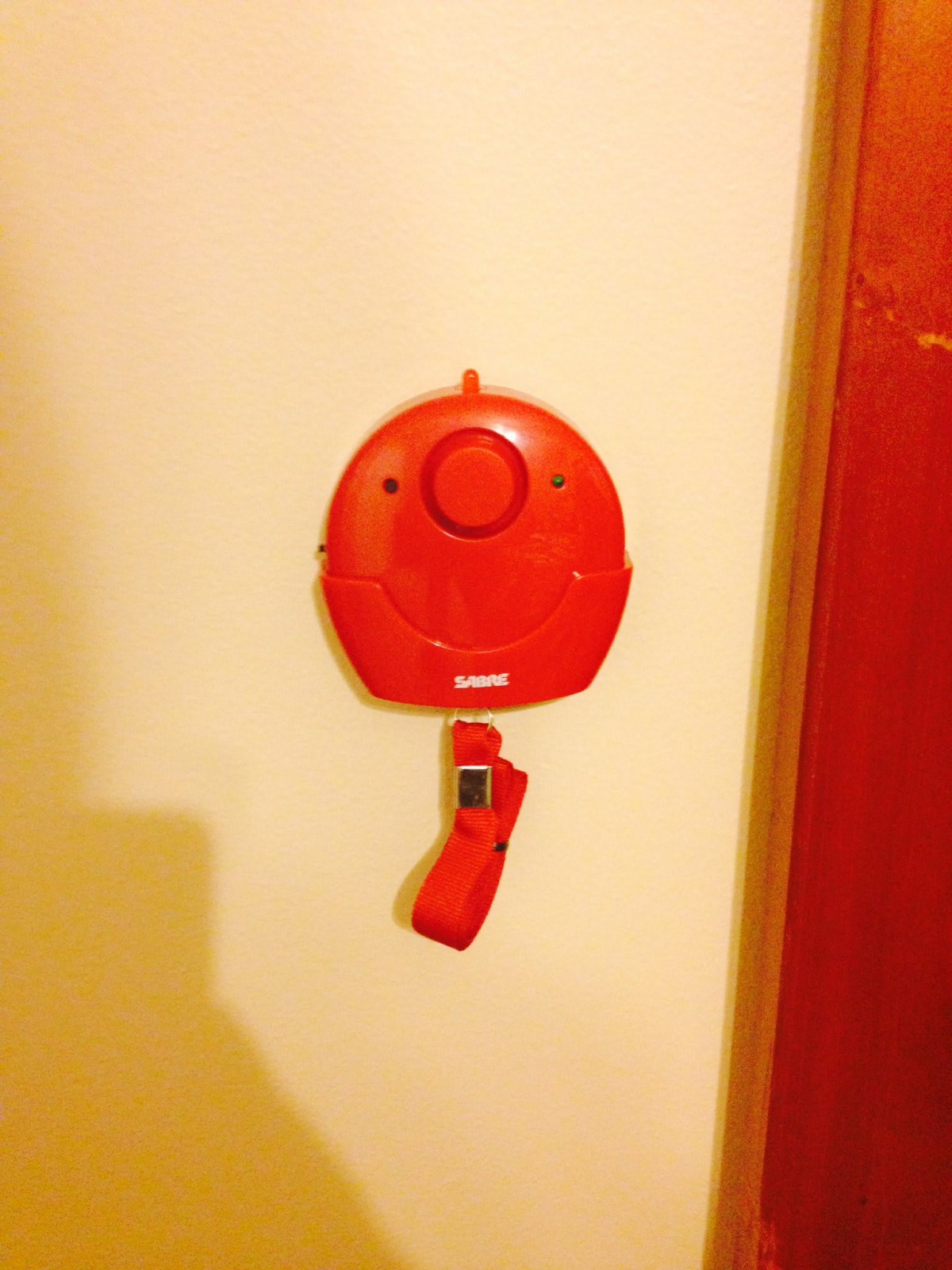 A red wall-mounted emergency alarm device.