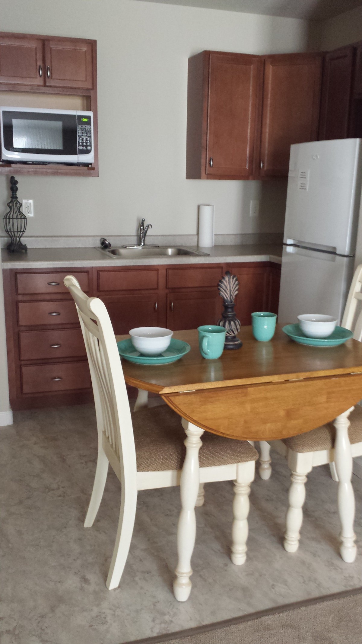 A cozy kitchen with a wooden dining table set for two.