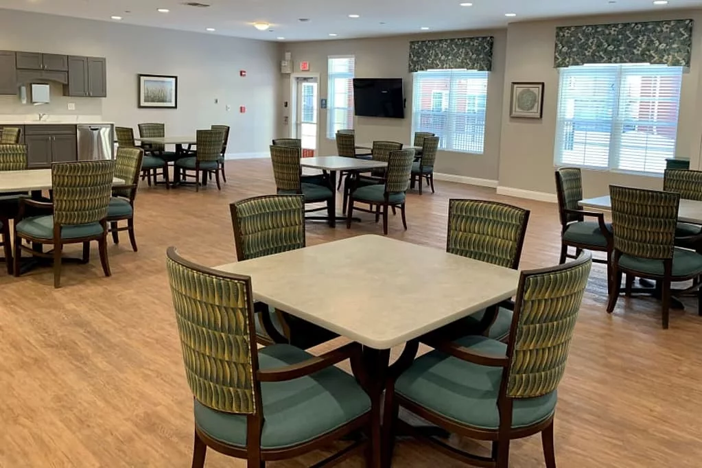 A well-lit dining area with multiple tables and chairs arranged for communal seating.