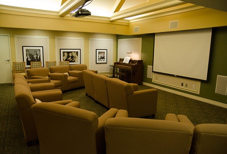 A cozy home theater room with comfortable seating and a large screen for viewing.