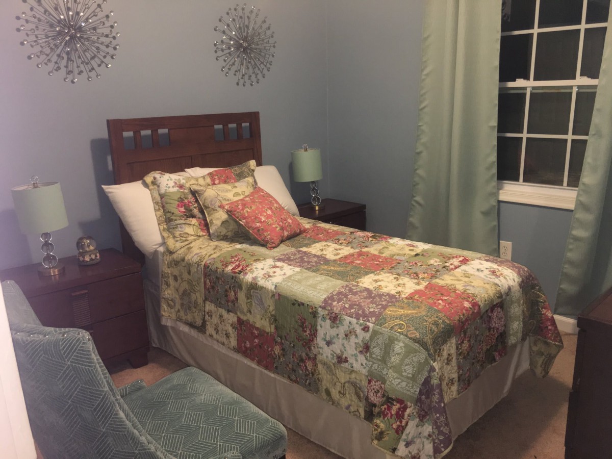 A cozy bedroom with a quilted bedspread and elegant decor.