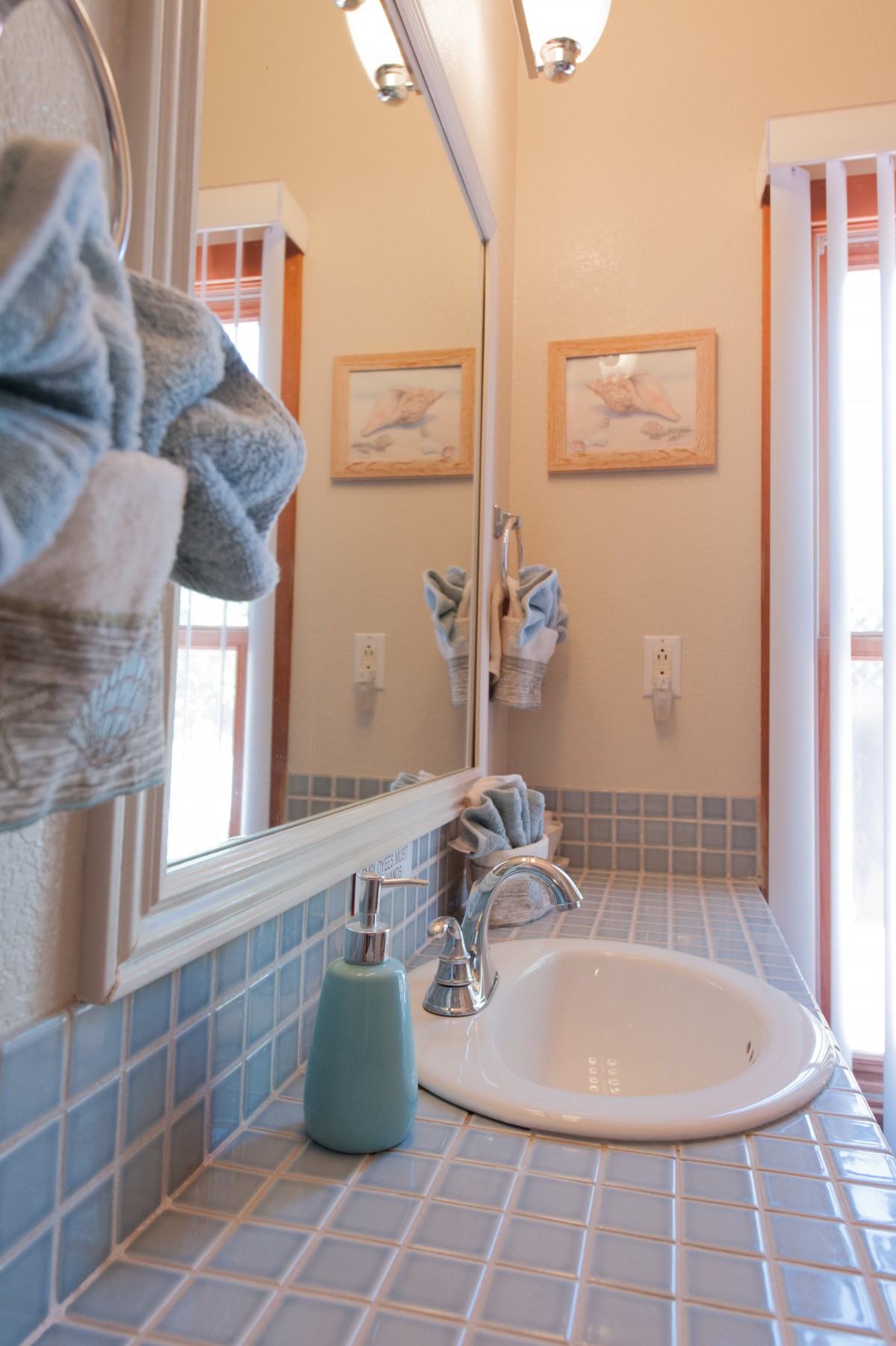 A cozy bathroom with a sink, mirror, and neatly arranged towels.