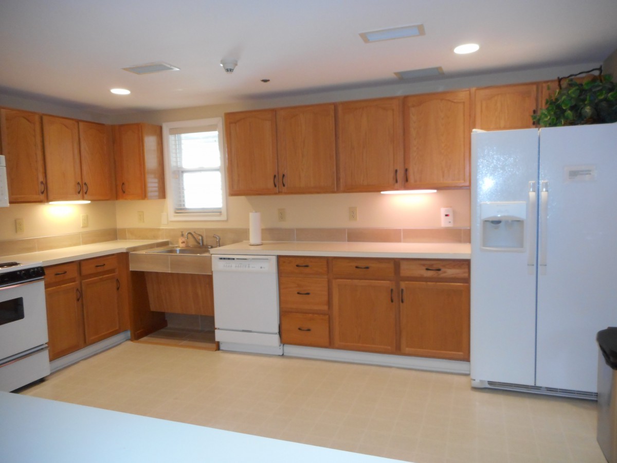 A spacious kitchen with wooden cabinets and modern appliances.