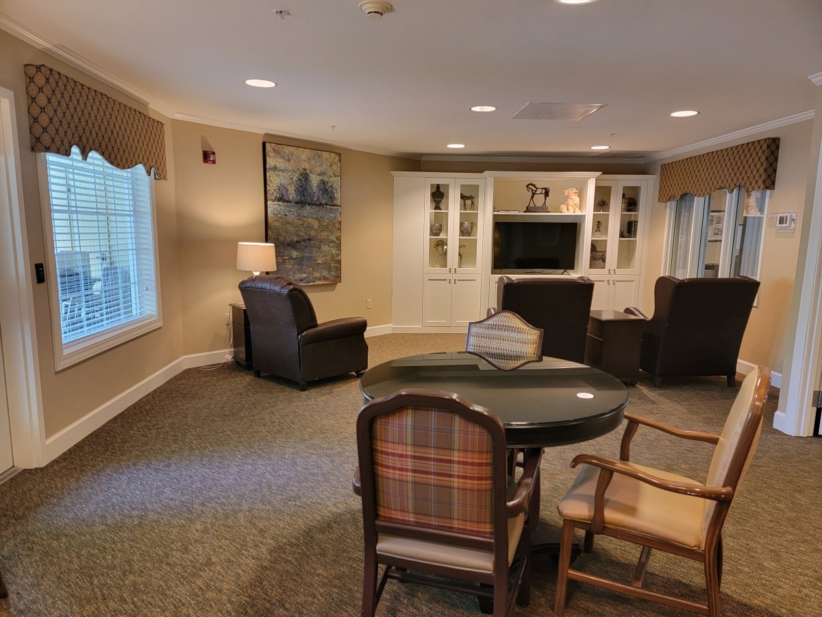 A cozy living room with armchairs, a television, and a small table.