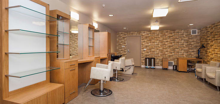 A modern hair salon interior with chairs and mirrors, featuring a stylish brick wall.