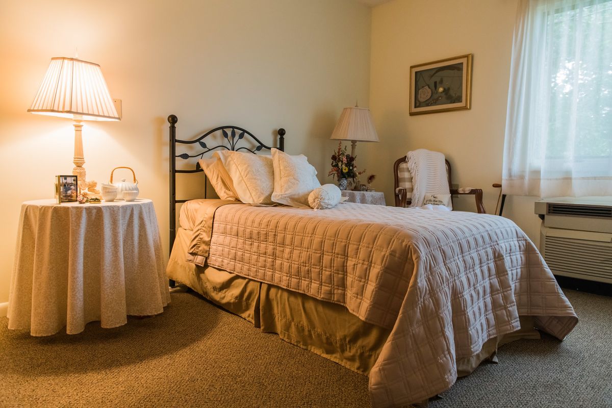 A cozy bedroom with a neatly made bed and soft lighting.