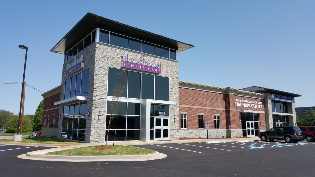 Exterior view of a modern medical clinic with large windows and a parking area.