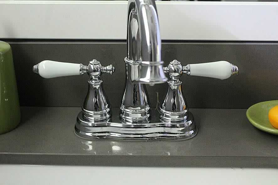 A chrome bathroom faucet with two white handles.