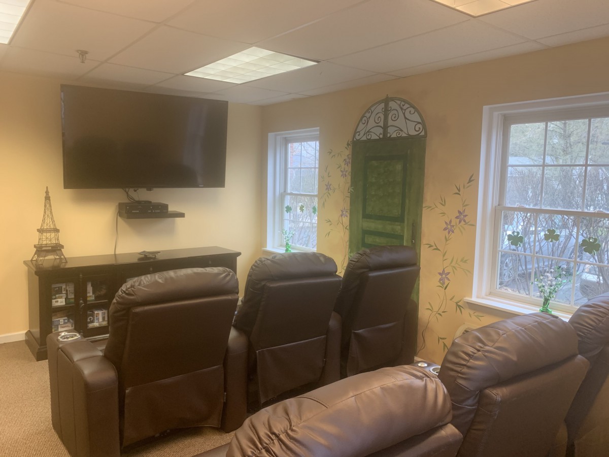 A cozy home theater setup with recliner chairs and a mounted television.