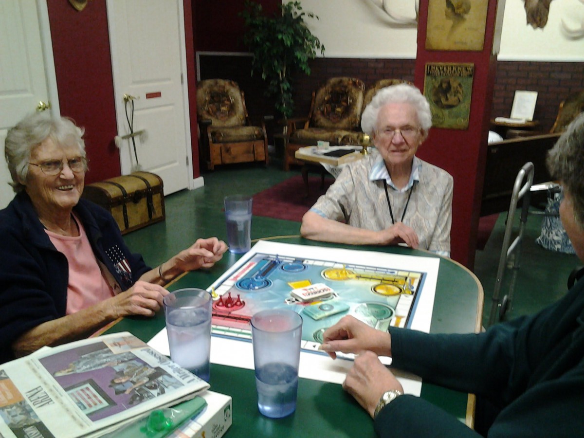 A group of seniors enjoying a board game together indoors.