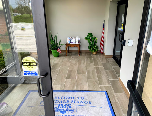 Entrance to an establishment featuring a welcome mat and decorative plants.