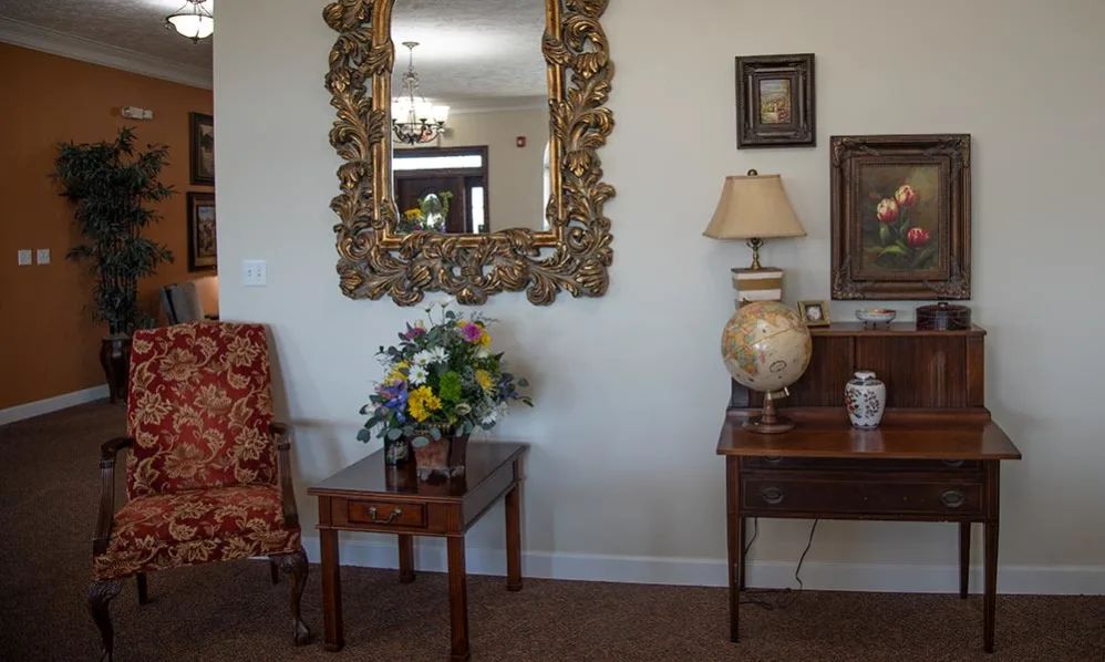 A vintage-style living room with an ornate mirror, wooden furniture, and elegant decor.