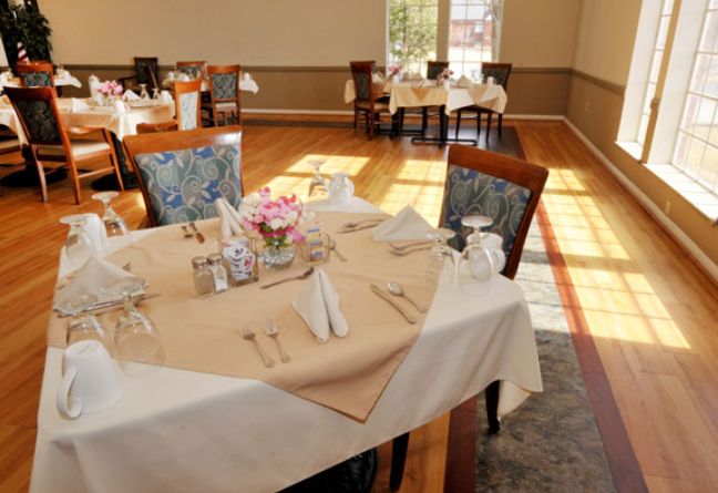 A beautifully set dining table in an elegant restaurant with natural lighting.