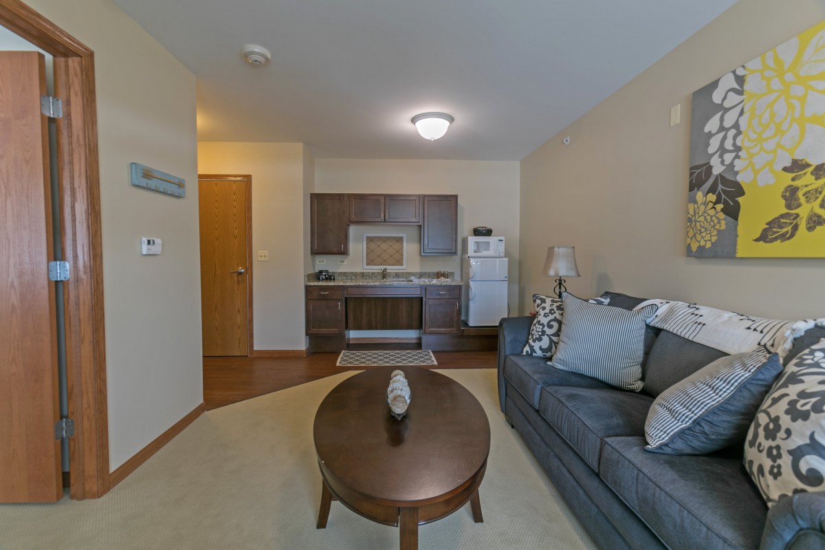 A modern apartment with an open layout featuring a cozy living room and kitchen area.