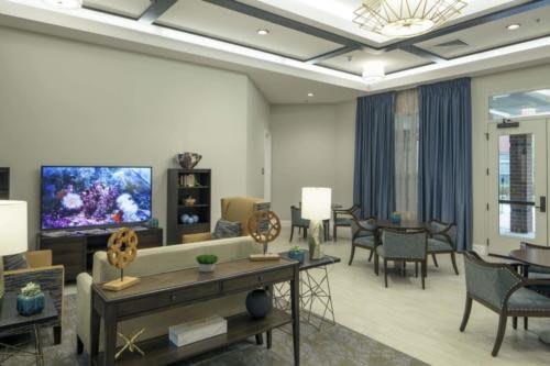 A modern living room with elegant furniture and a large TV.