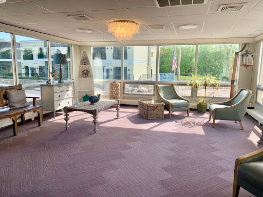 A bright and modern lounge area featuring comfortable seating and large windows, creating a cozy atmosphere.