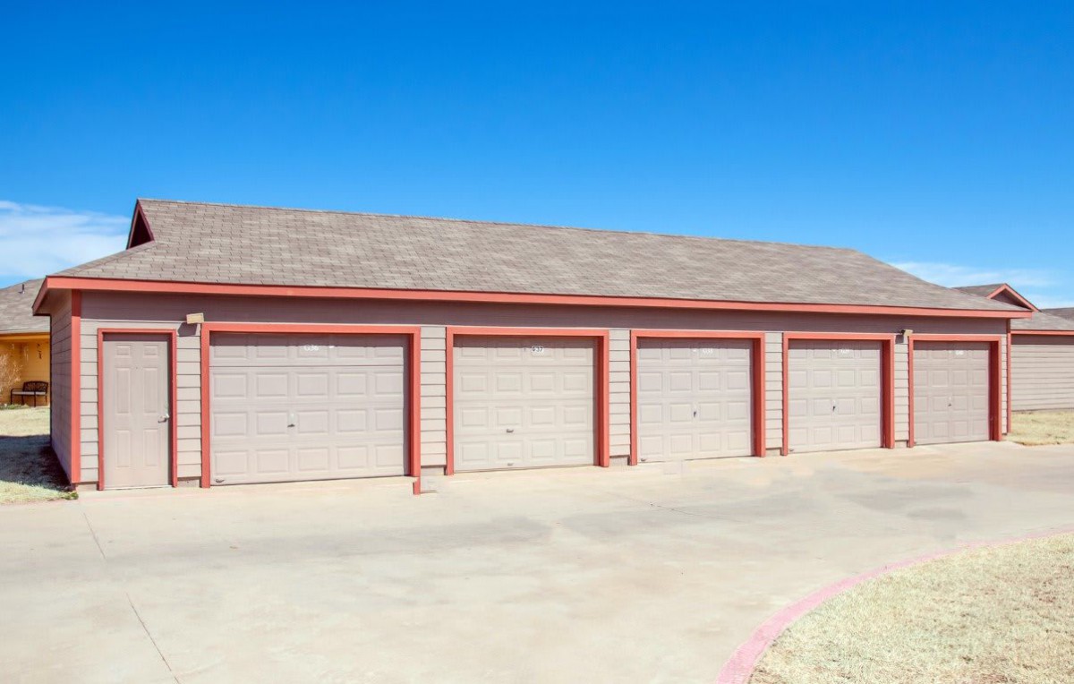 A row of closed garage doors under a clear blue sky.