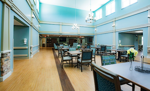 A bright and spacious dining room featuring blue walls and modern furnishings.