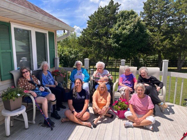 A group of women enjoying a sunny day on a patio.