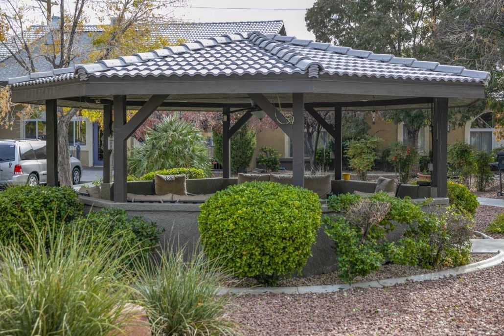 A Japanese-style pavilion surrounded by lush greenery in a tranquil garden setting.