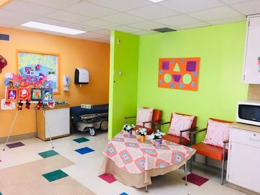 A vibrant and welcoming children's waiting area in a hospital, featuring bright colors and comfortable seating.