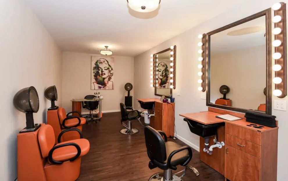 A well-appointed salon interior with styling chairs, mirrors, and warm lighting.