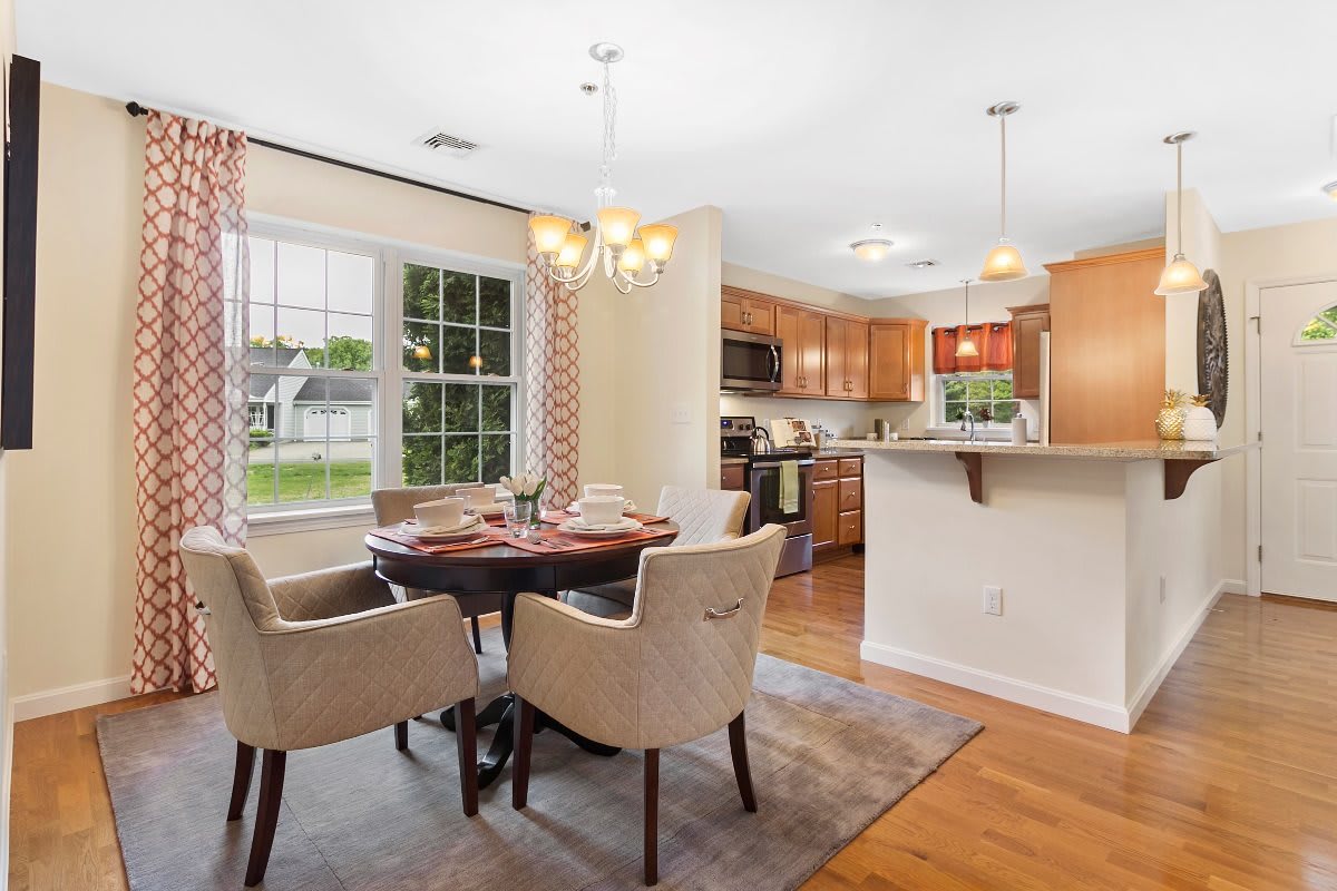 A cozy dining area with a table and chairs adjacent to an open kitchen.