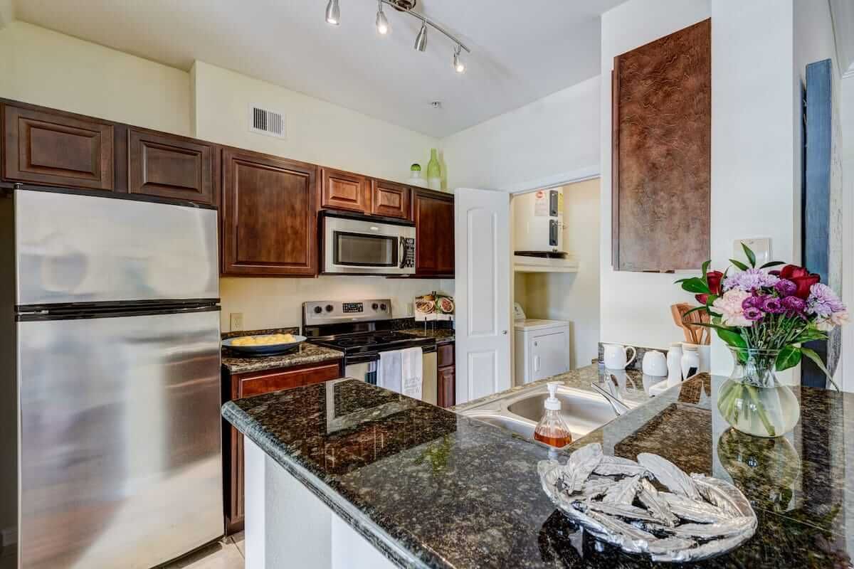 A modern kitchen with stainless steel appliances and granite countertops.