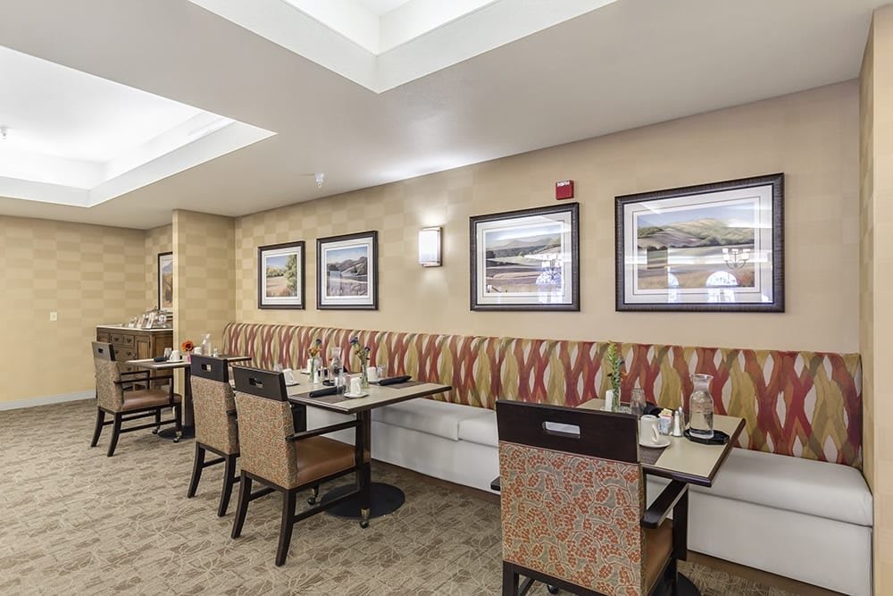 An inviting dining area with tables, chairs, and framed artwork on the walls.